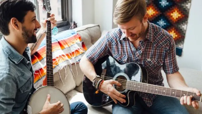 2 men playing guitar